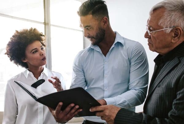 Errors and Omissions Insurance - Business Colleagues Discussing E_O Legal Advice over a Business Report in the Office