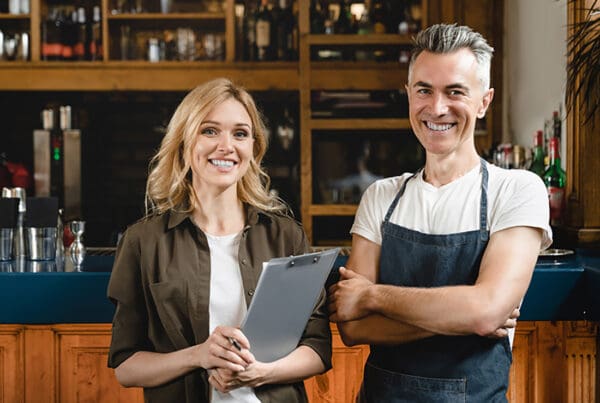 Franchise-Insurance-Two-Business-Onwers-Siming-in-Front-of-Their-Bar